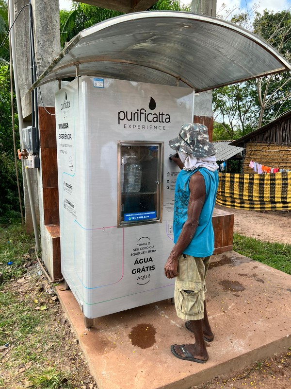 Morador utilizando a máquina Purificatta em comunidade