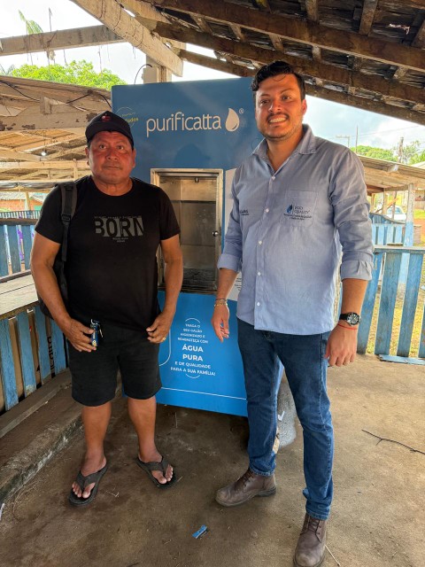 Equipe Purificatta com morador ao lado da máquina