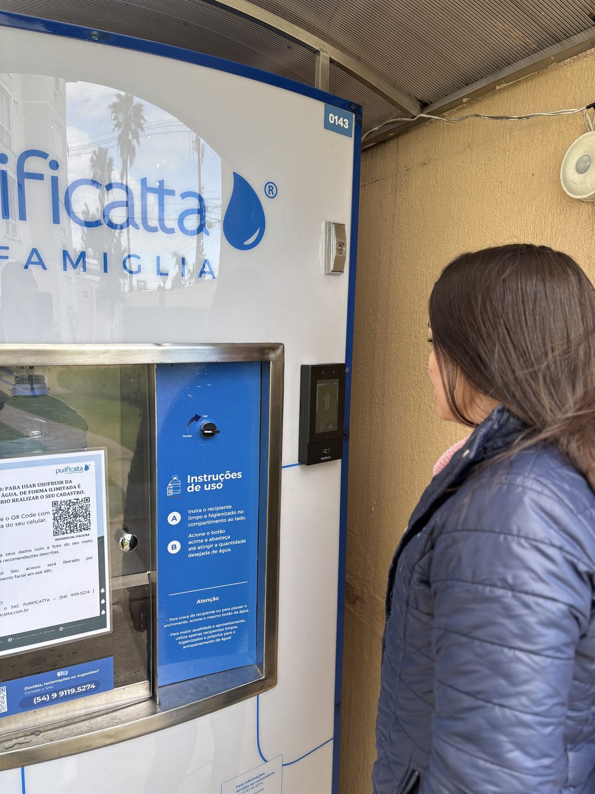 Moradora em frente à Famiglia, com as instruções de uso